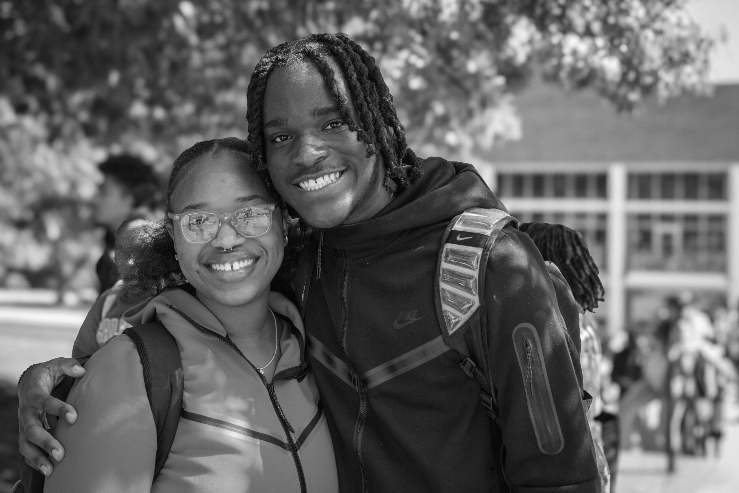 Two students with their arms around their shoulders.