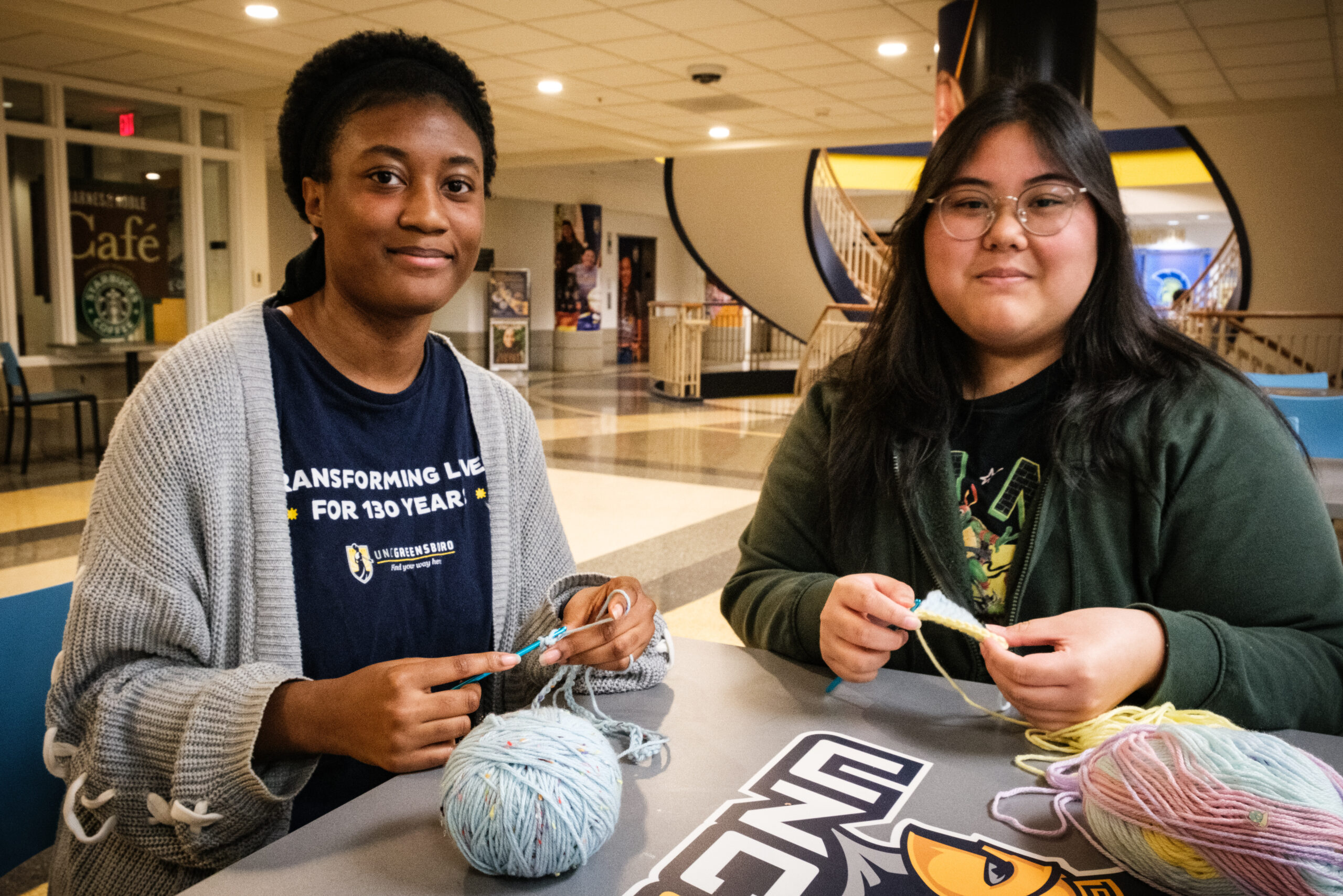 Two UNCG students crochet.
