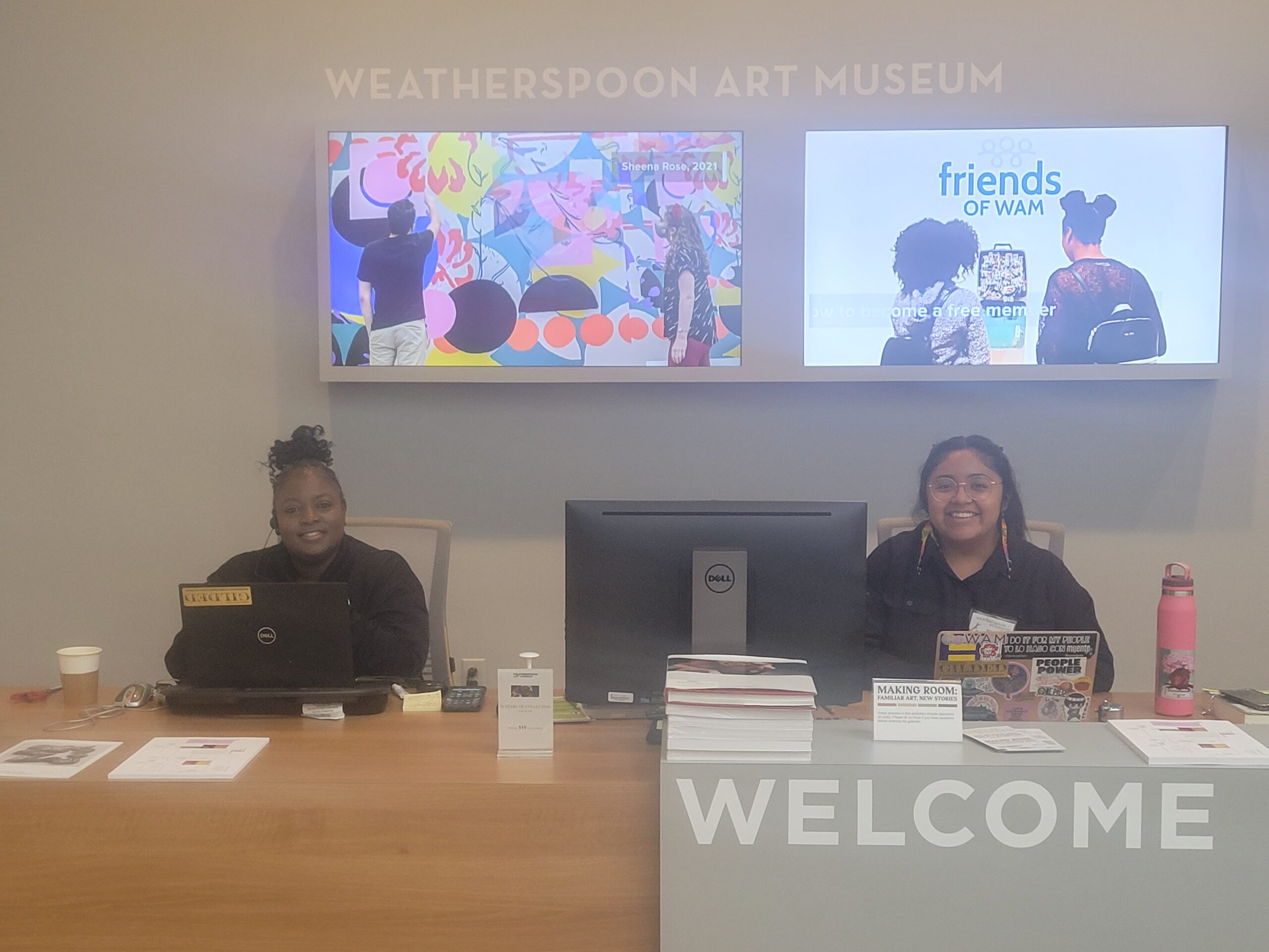 Staff sit at the welcoming desk of the UNCG Weatherspoon Art Museum.