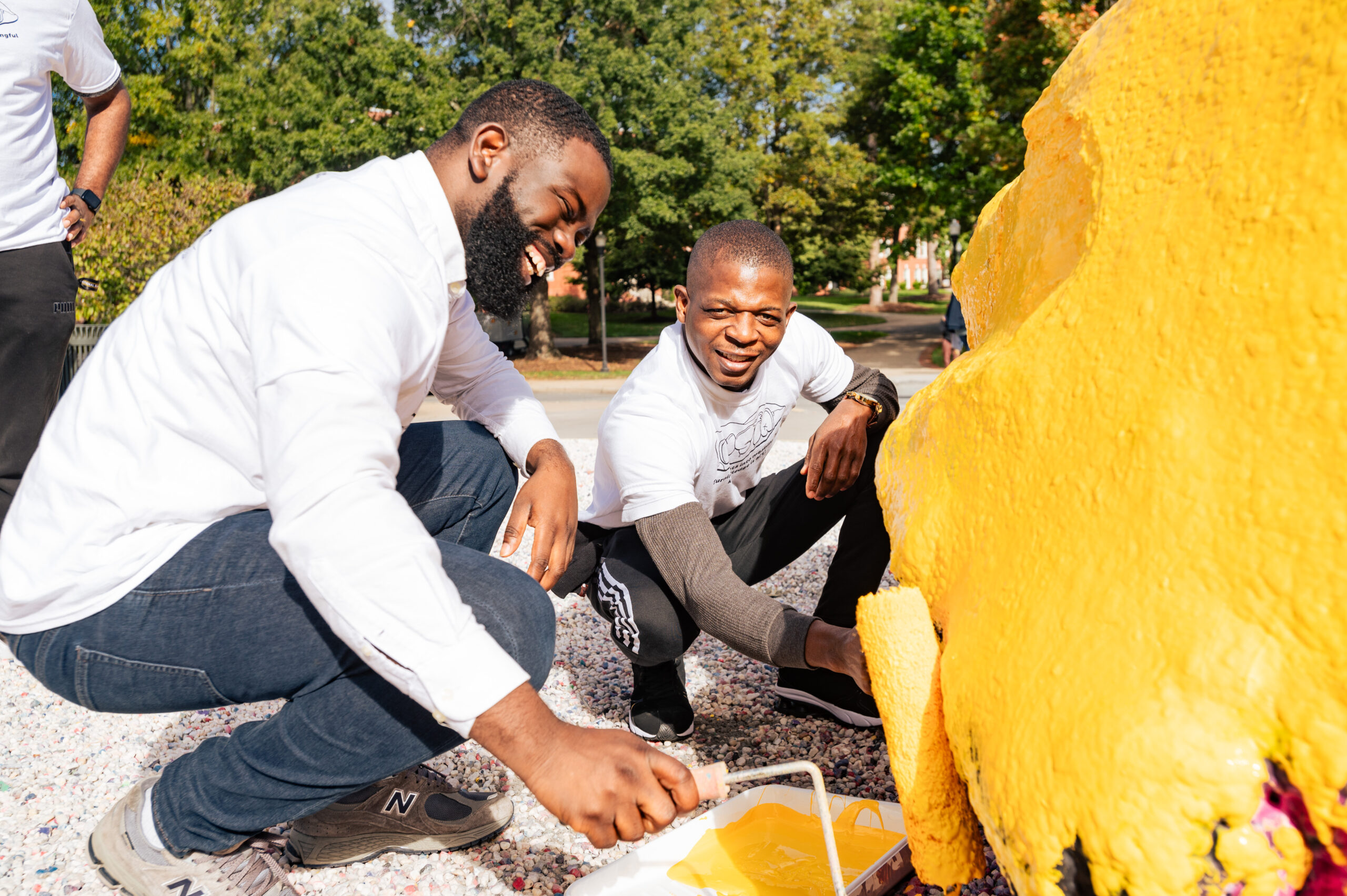 UNCG students painting The Rawk