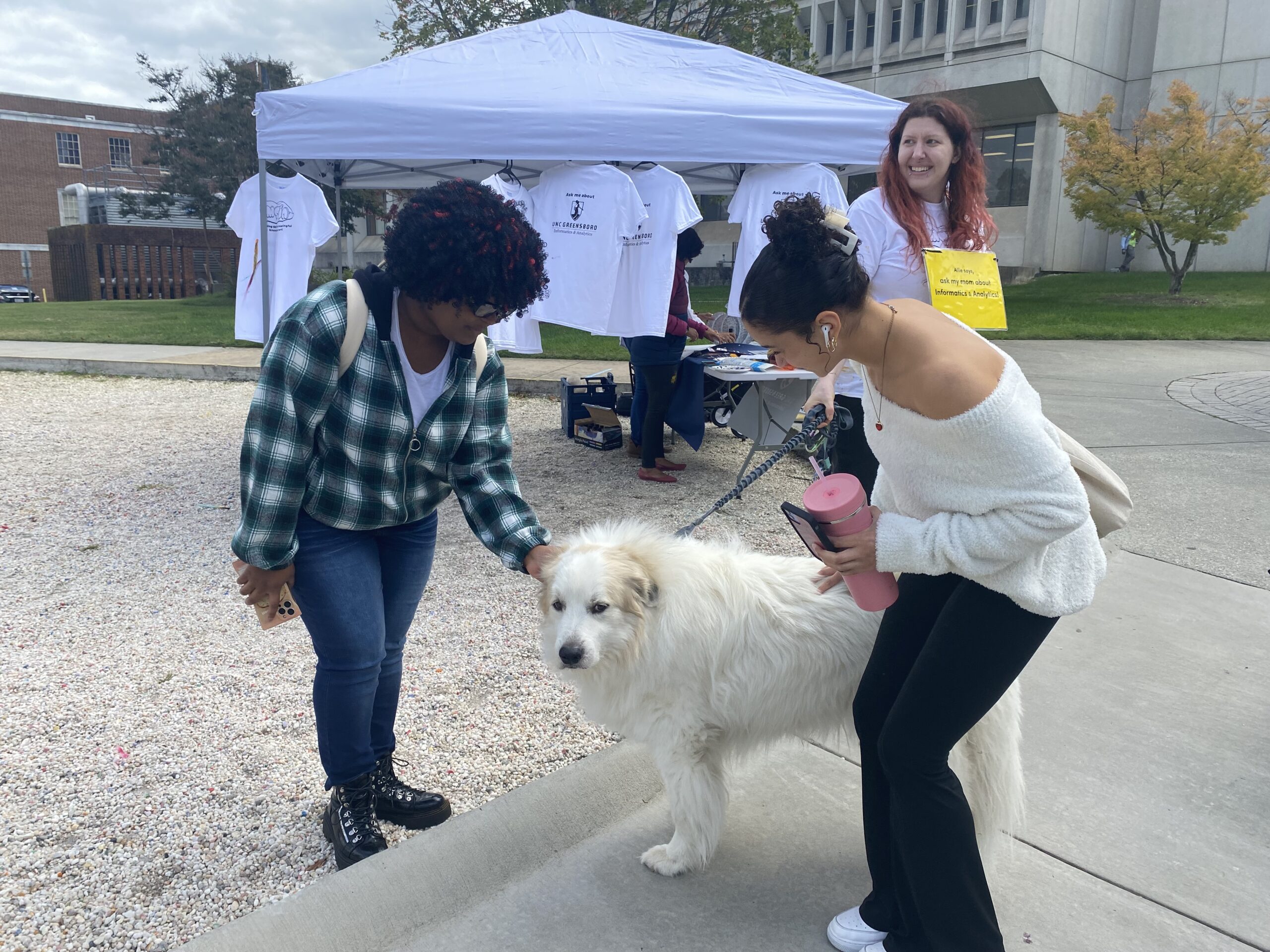 Students pet a dog at UNCG.