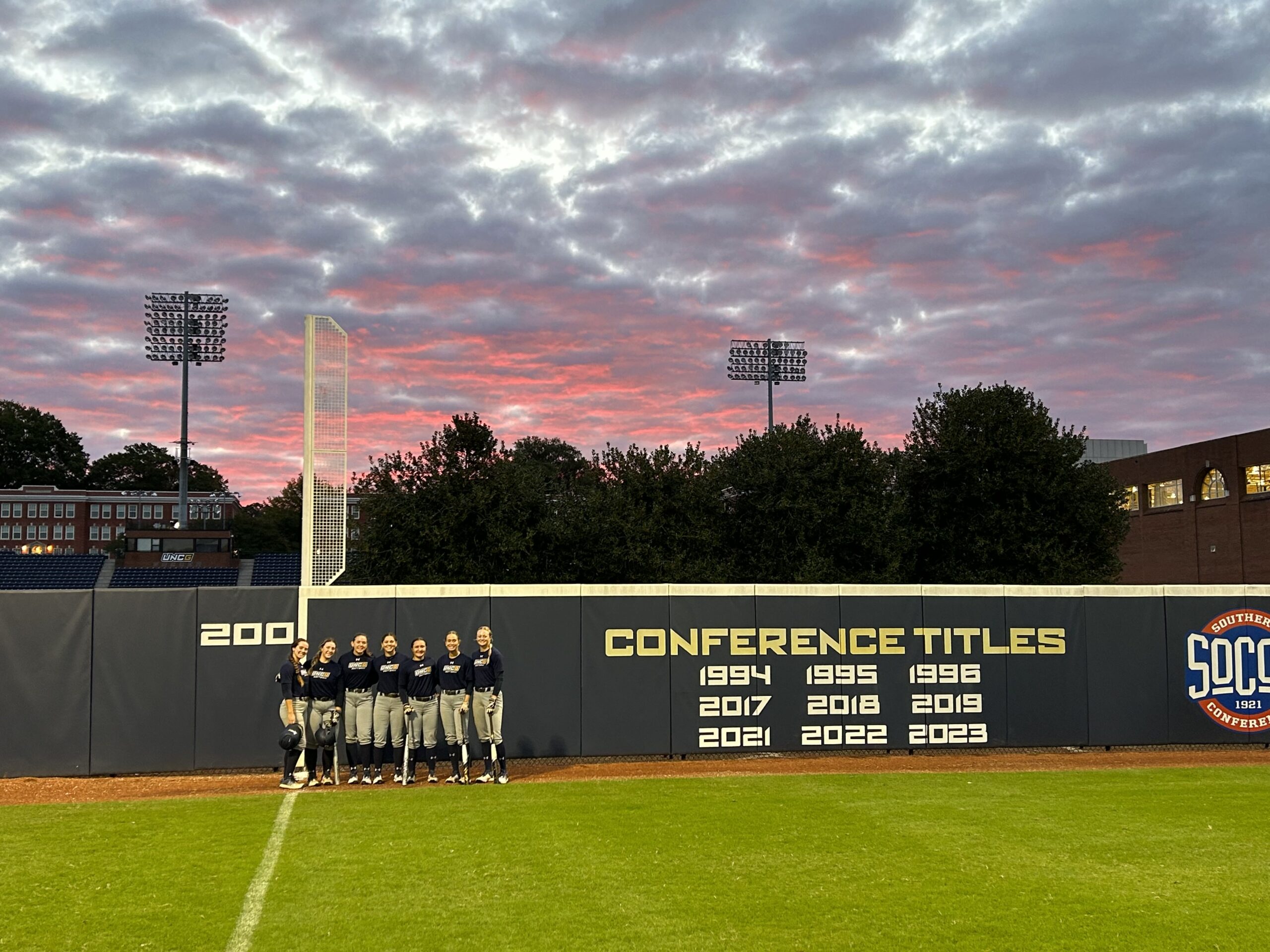 UNCG softball student-athletes pose during their Wednesday morning session under a beautiful skyline.