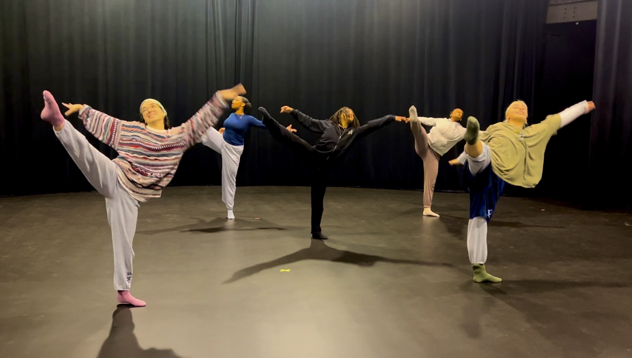 UNCG students practice dance on a stage.