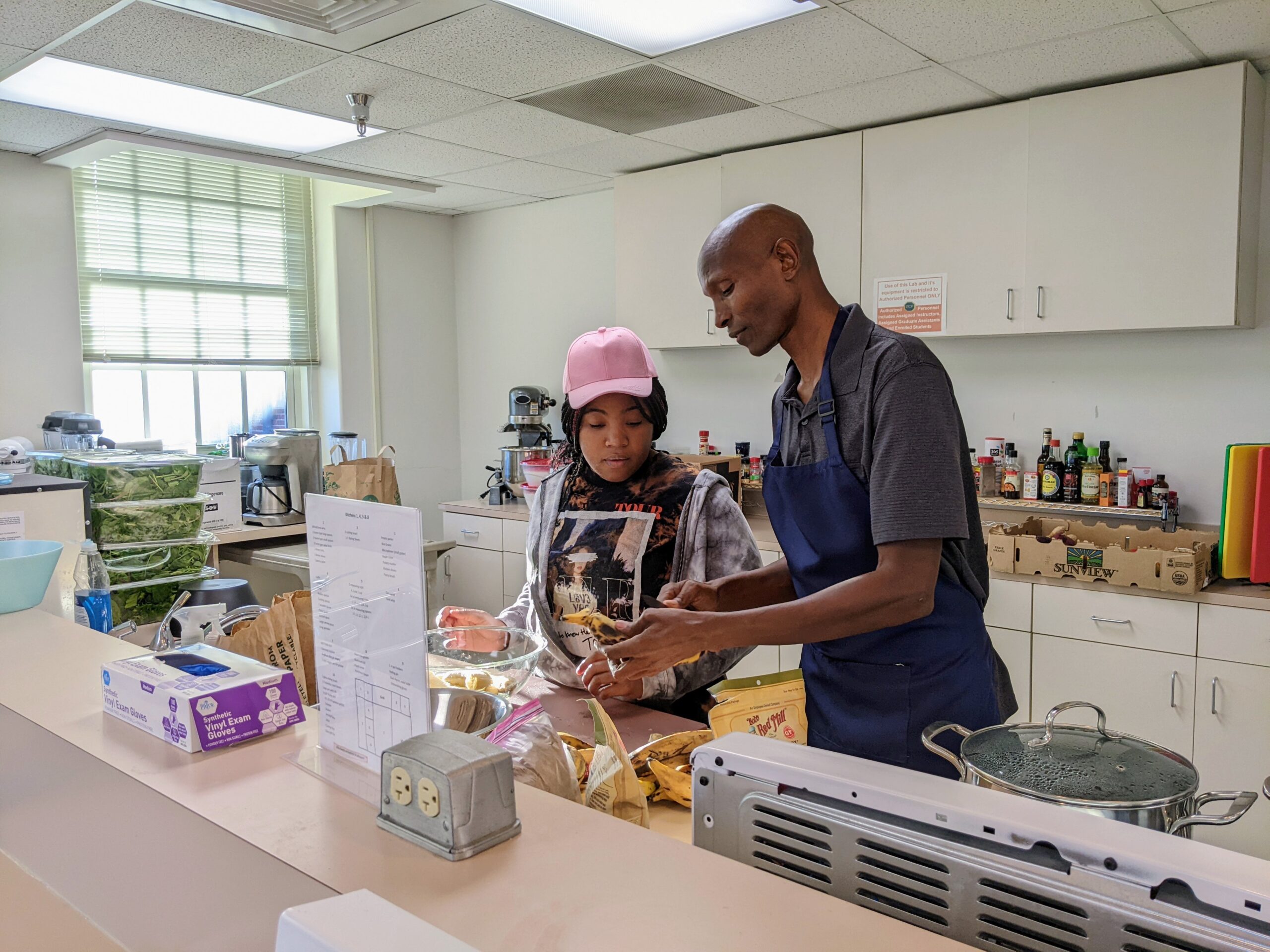 Chef Njathi Kabui mentors a student in the Kitchen Lab at UNCG's Stone Building.