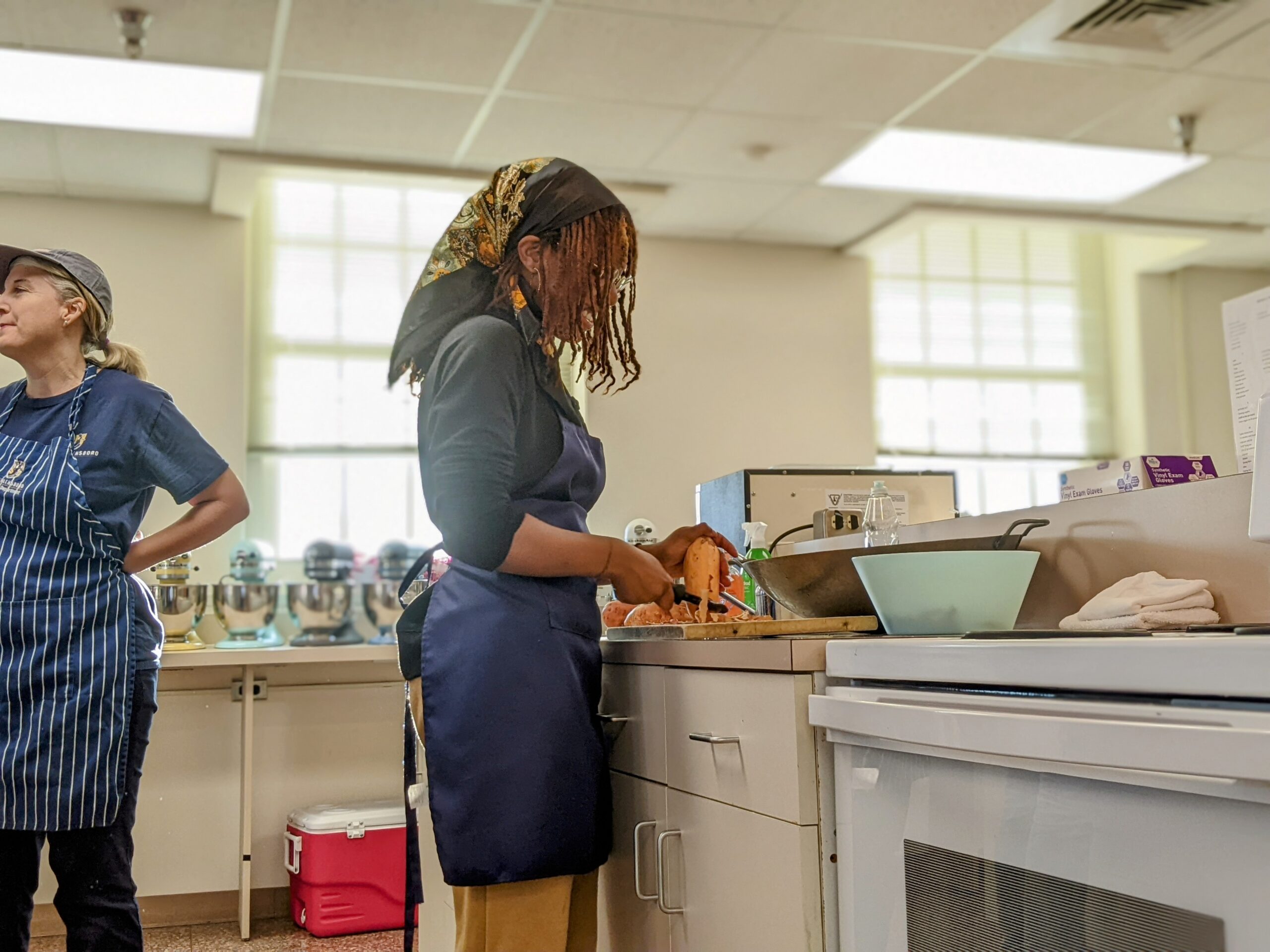 A UNCG student peels potatoes during a kitchen lab.