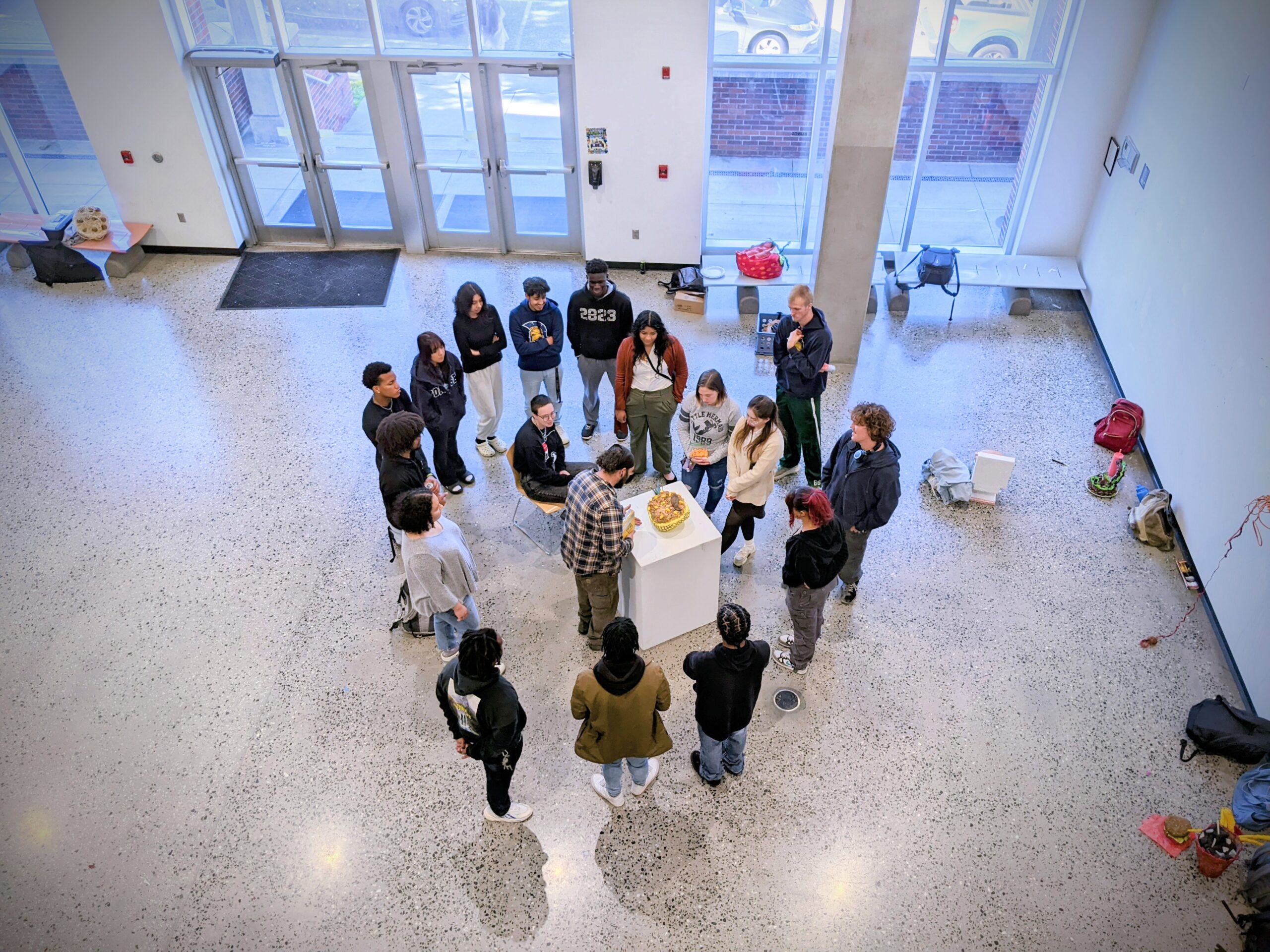 UNCG students stand around a sculpture for a class critique as their professor leads the discussion in the Gatewood Studio Art Building.