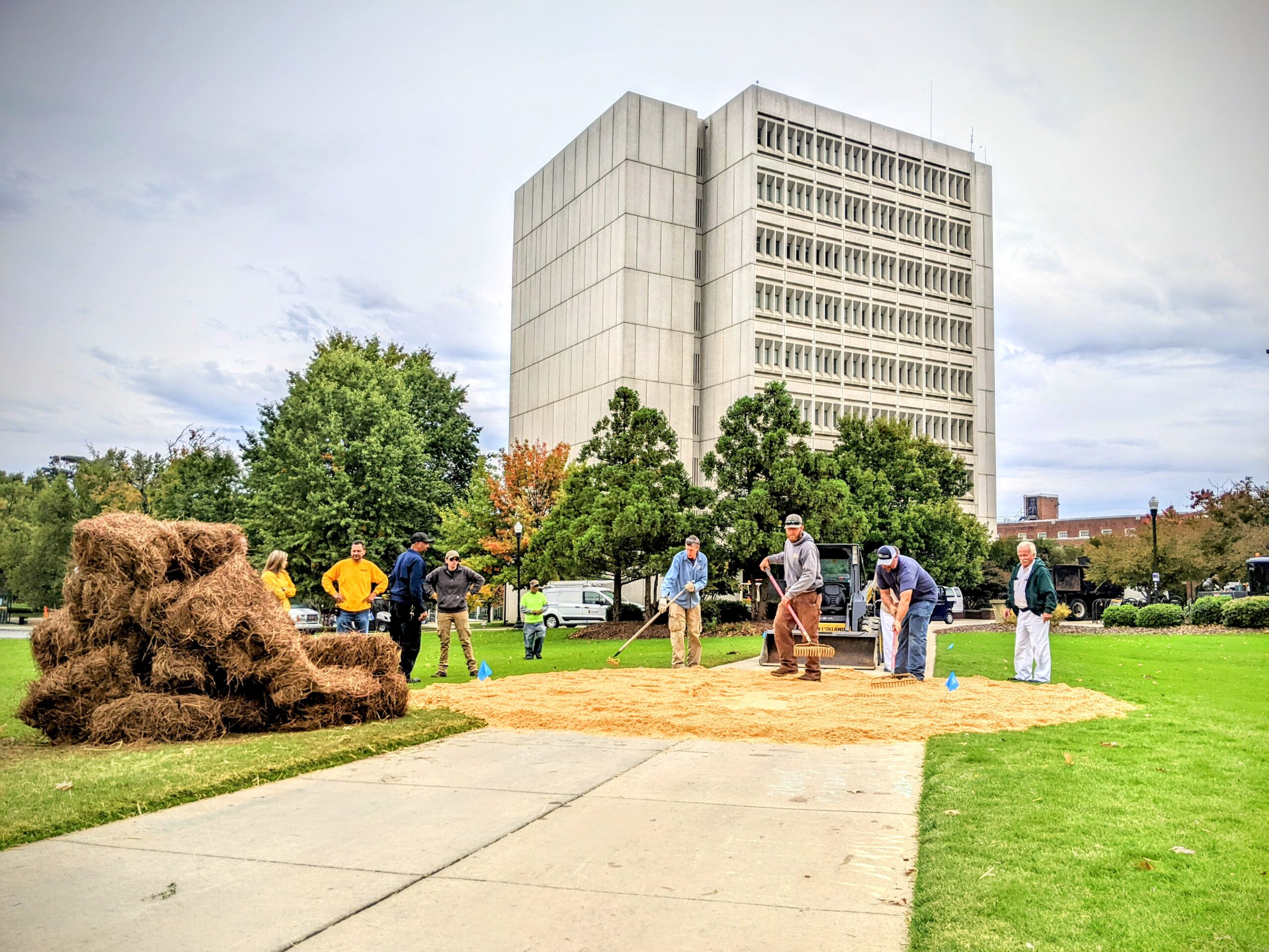 UNCG staff spread sand for a Homecoming bonfire.