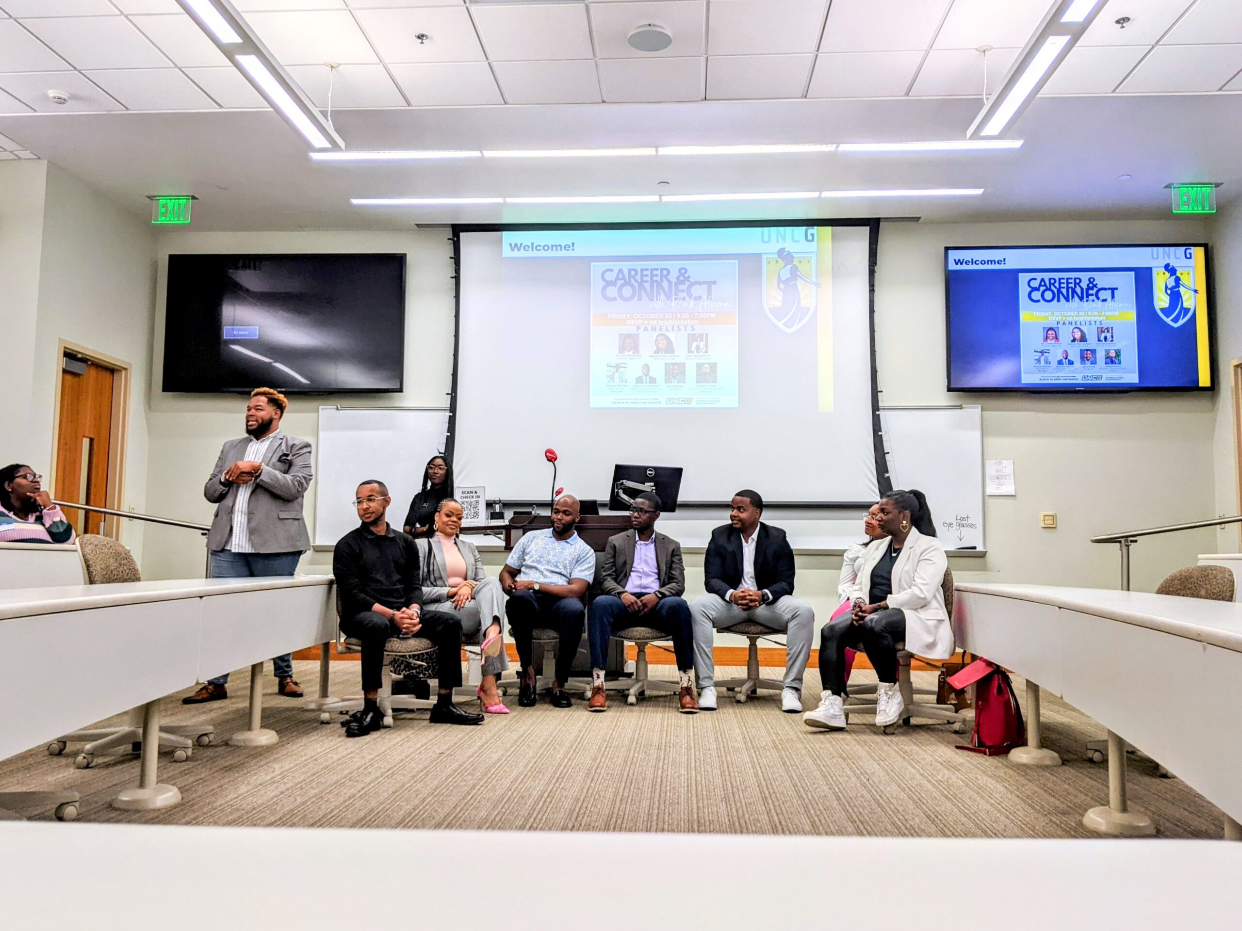 Group of adults seated in front of a A/V screen in a classroom.