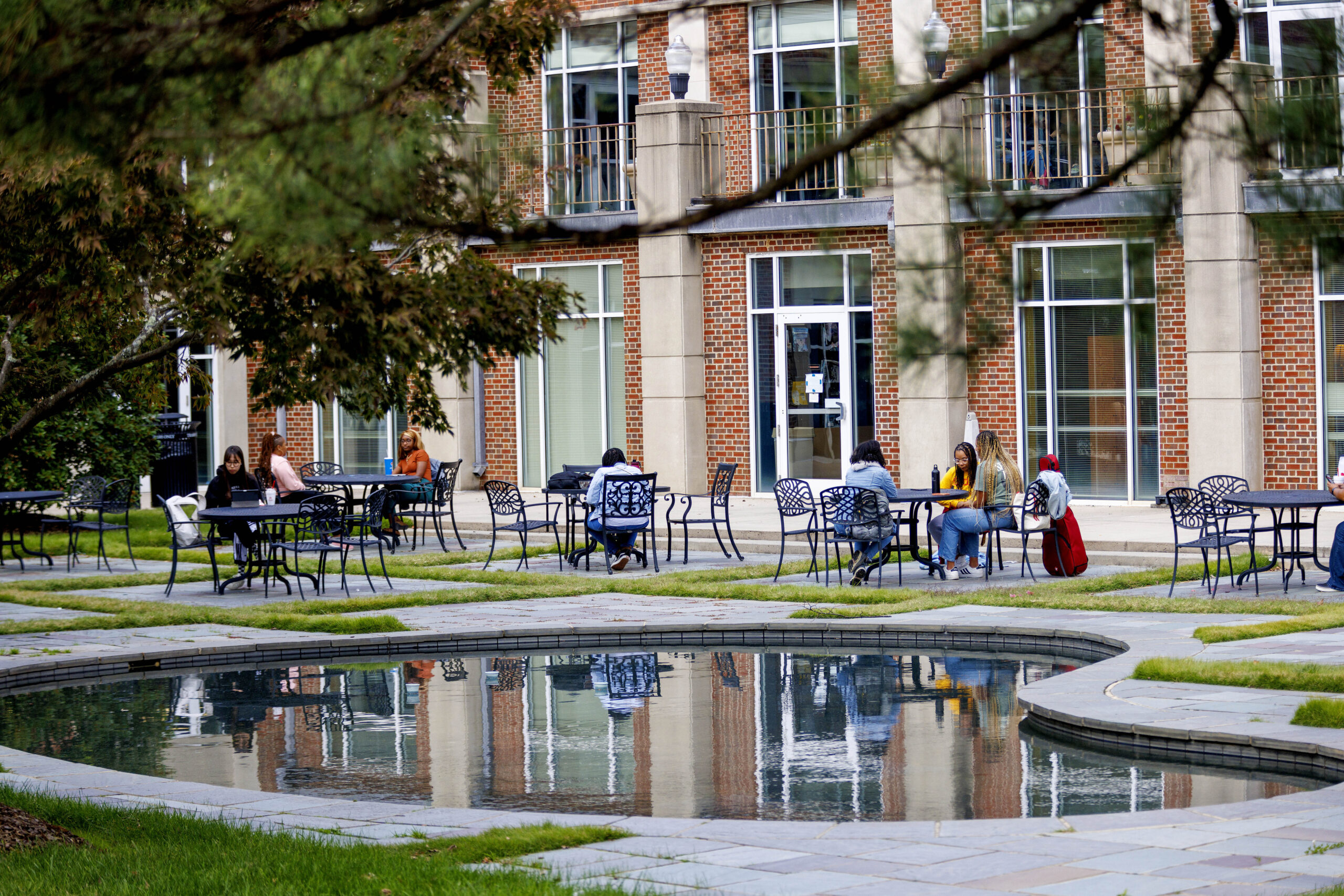 Students enjoy a mid afternoon break on Wednesday, finding a quiet place at the reflecting pool and fountain behind the Alumni House.