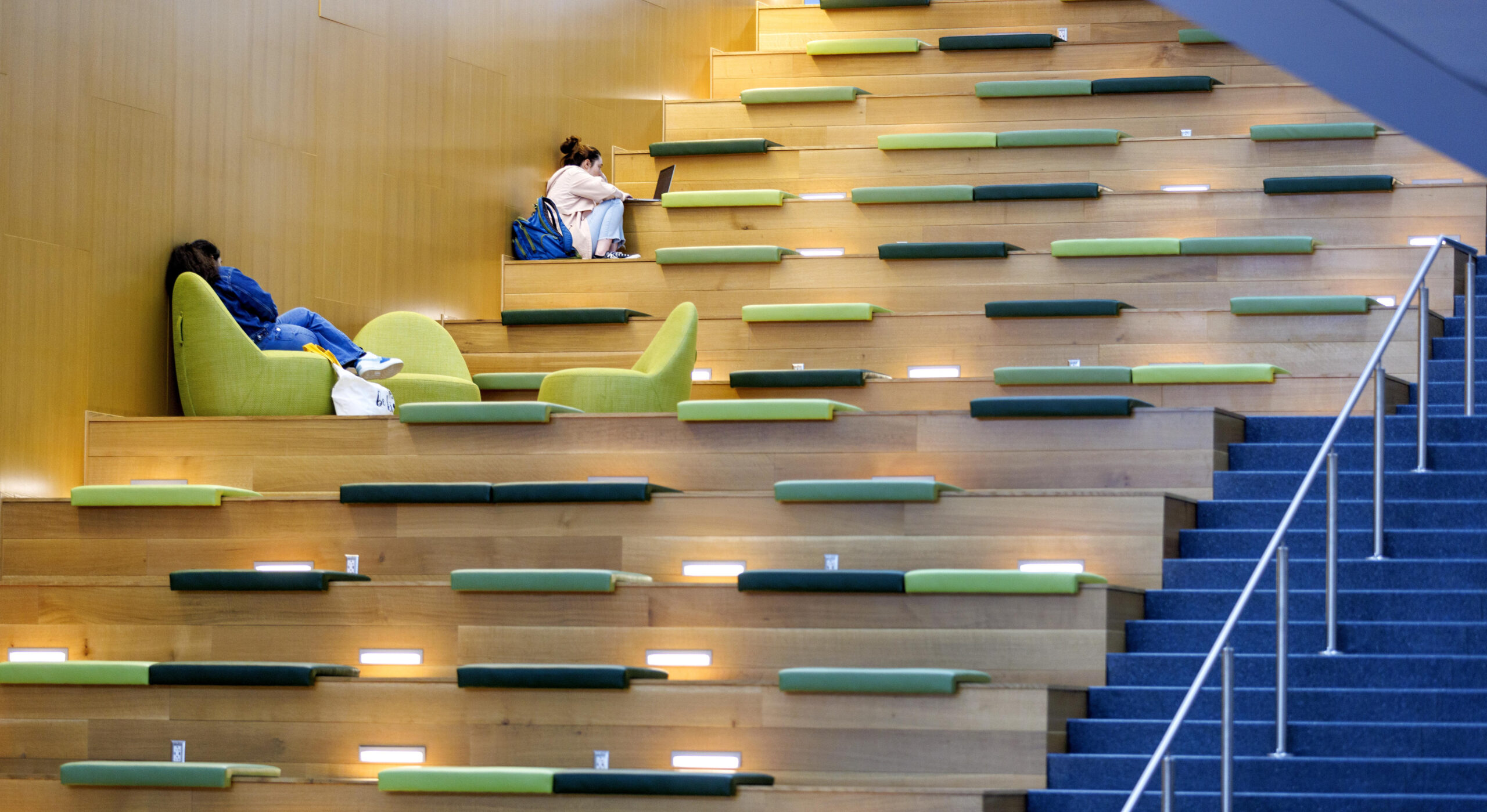 Two students study on the stairs in the Nursing and Instructional Building.