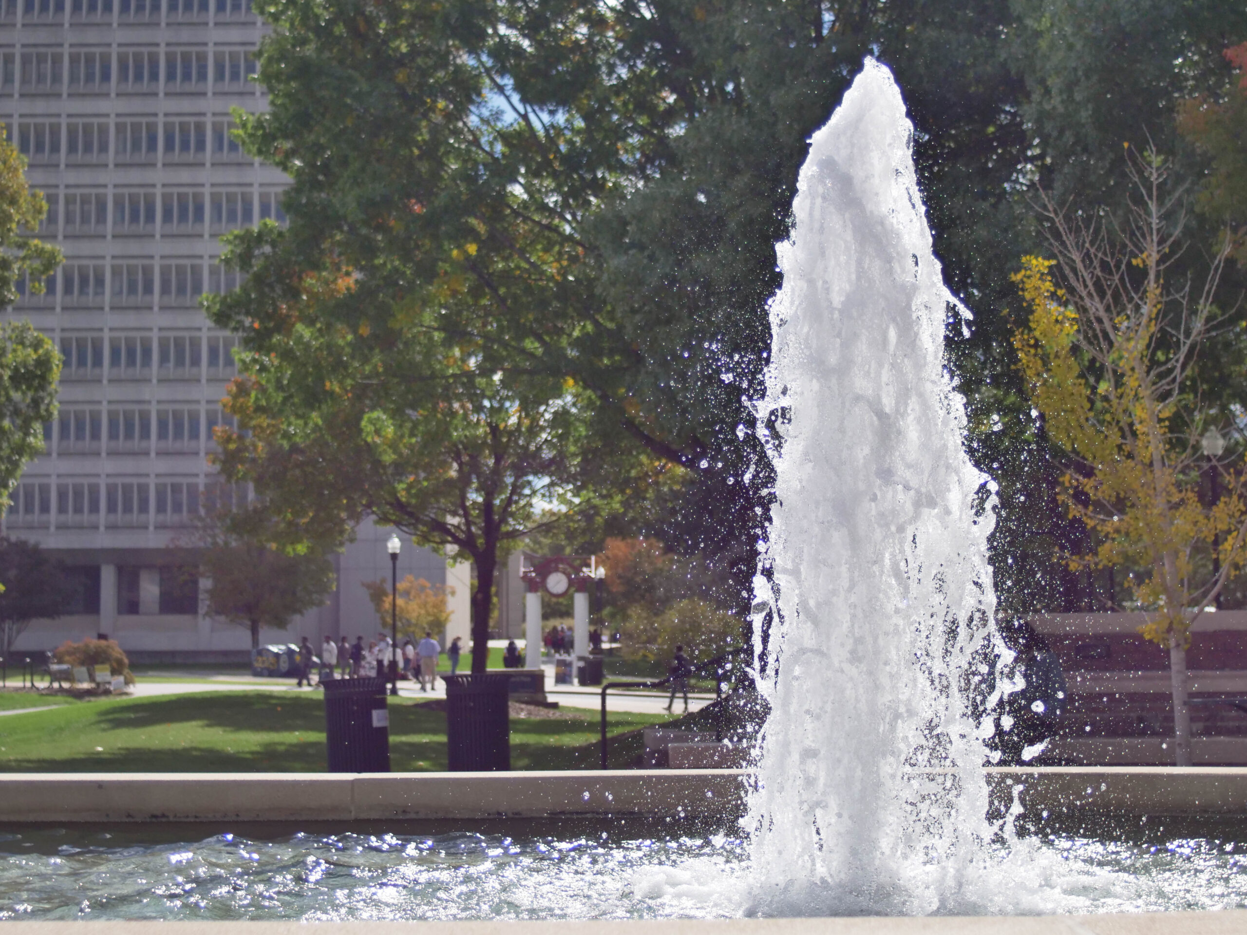 The fountain at Moran Commons with the Jackson Library and UNCG clocktower seen in the background.