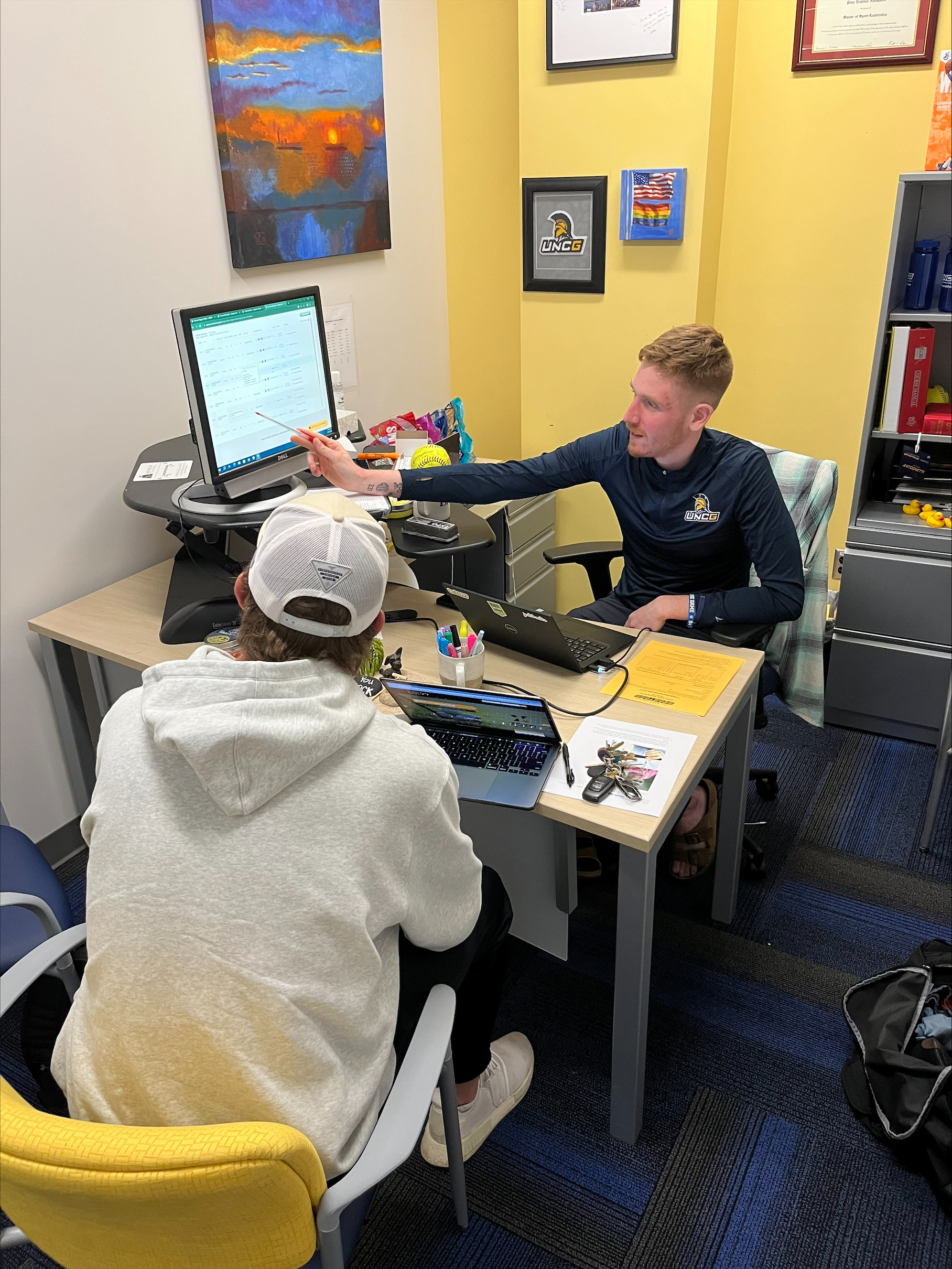 Academic Coach and Student-Athlete Development Coordinator Peter Antognetti assists junior baseball student-athlete Brandon Hudson with his classes.