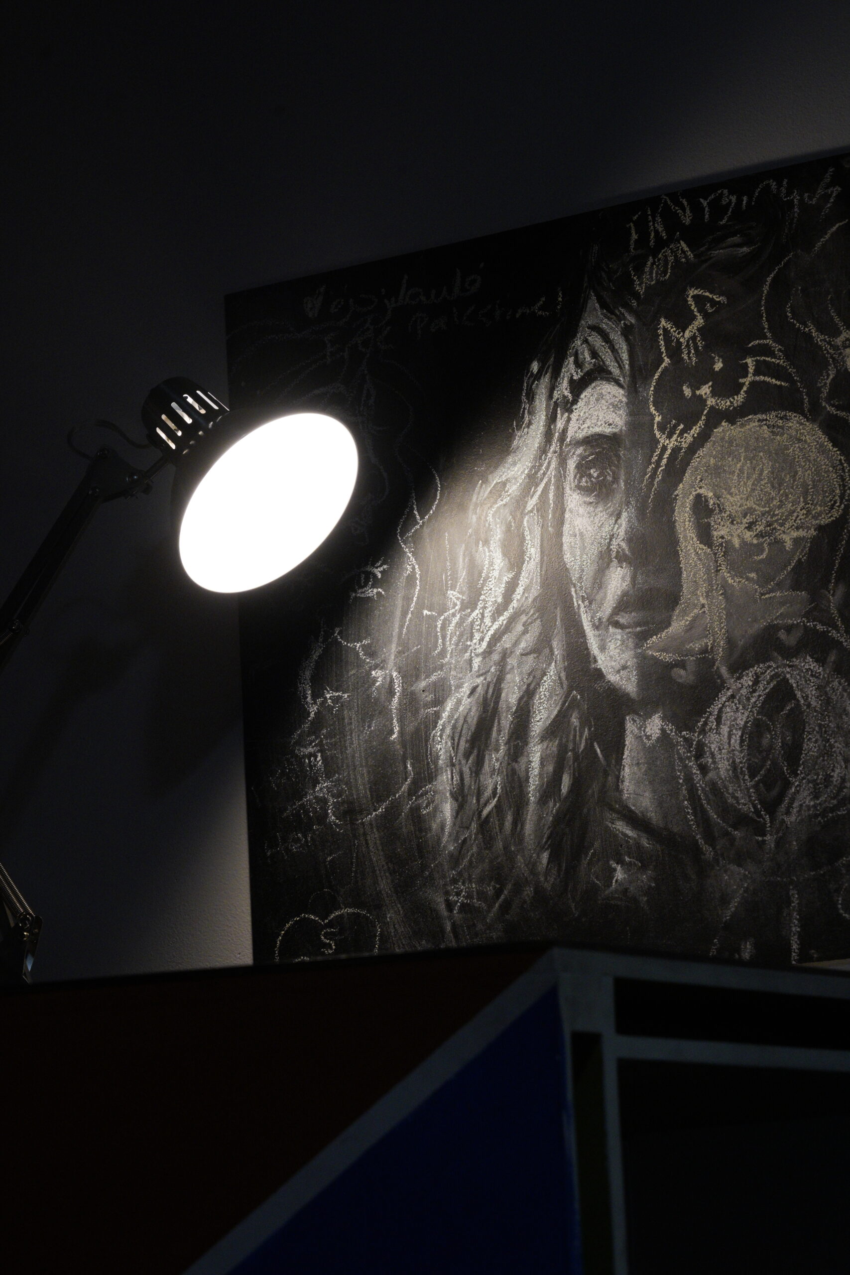 Drawing in chalk is lit by a lamp.
