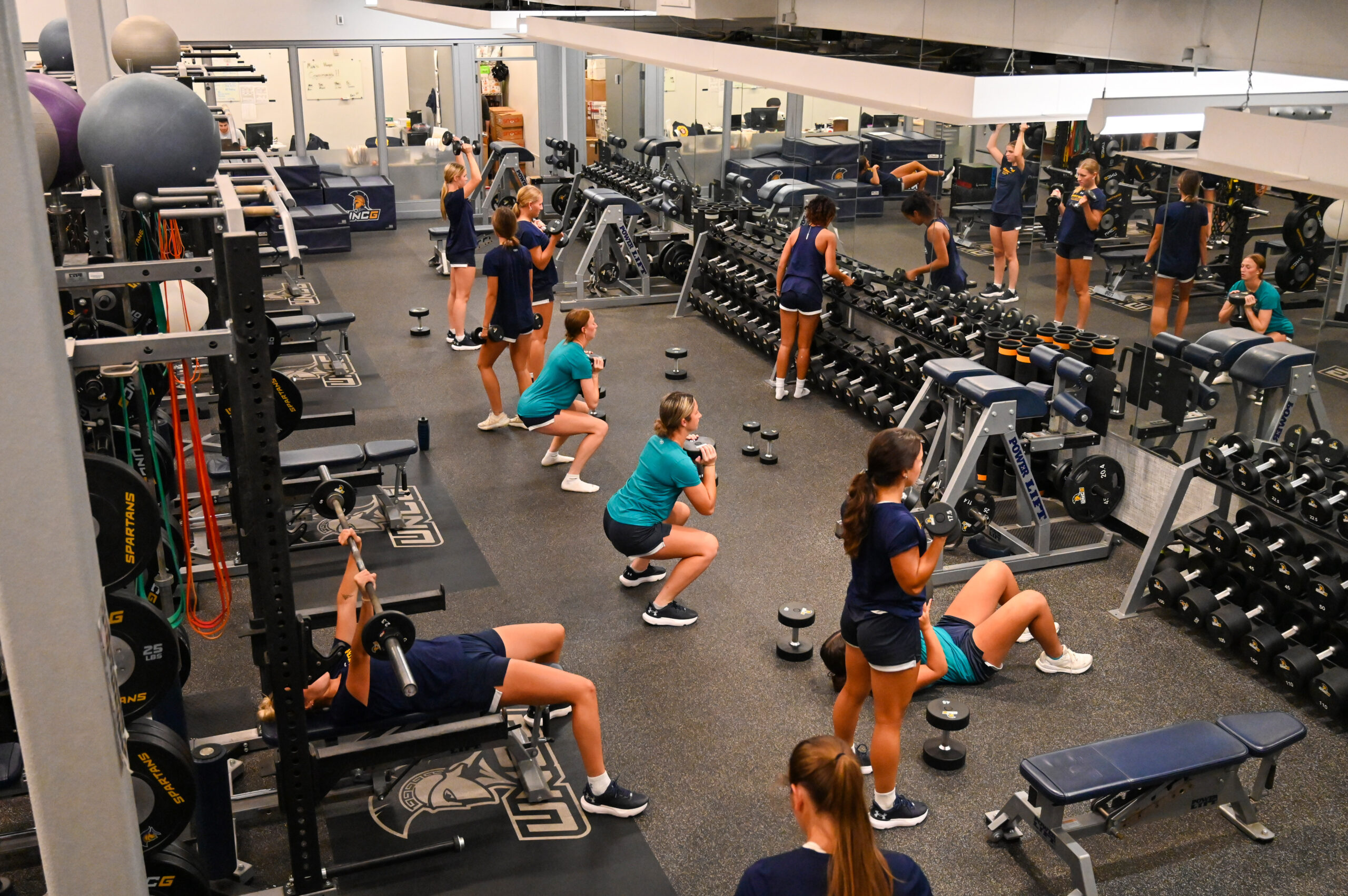 Women's soccer players lifting weights in the Bodford Strength Training Center - Coleman Building