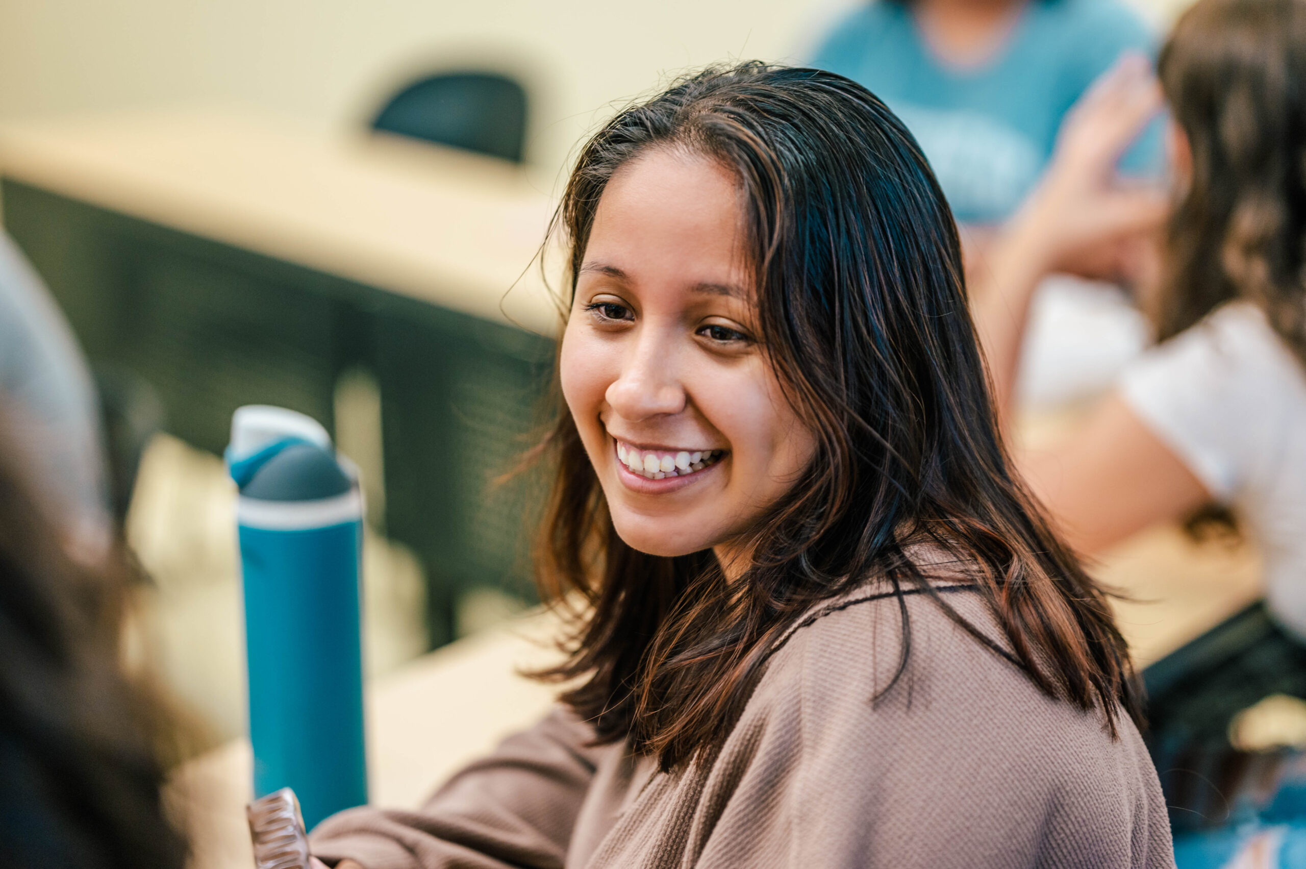 Student smiling in classroom.