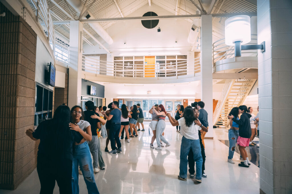 About 30 students dance in pairs inside of the Coleman building as part of a Ritmo Latino event.