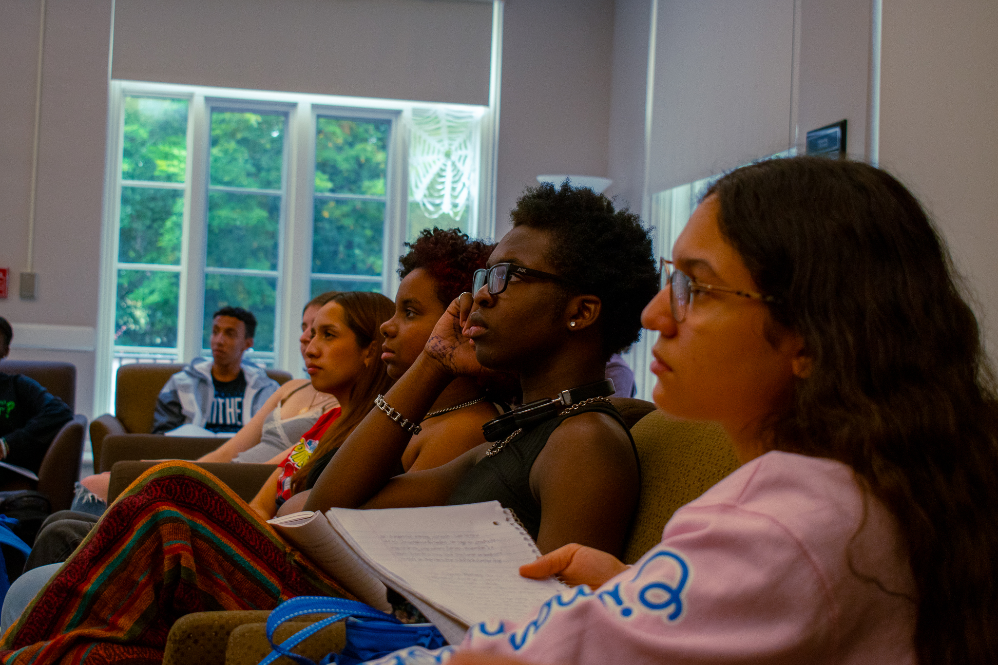 Five students listening to someone speak in the Guilford Residential College