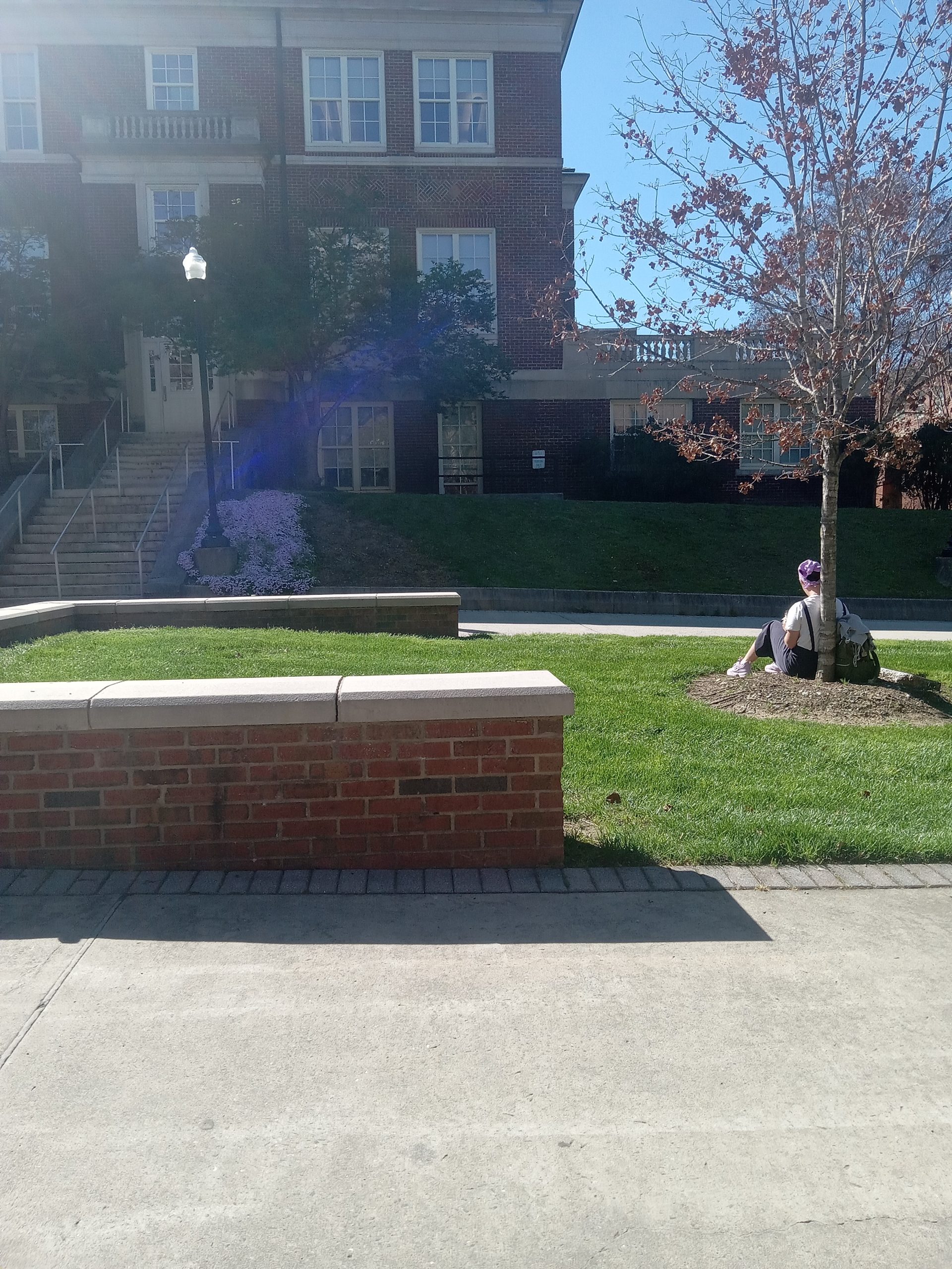 A student takes advantage of Monday's warm weather while sitting on the grass between the Stone and Eberhart Buildings.