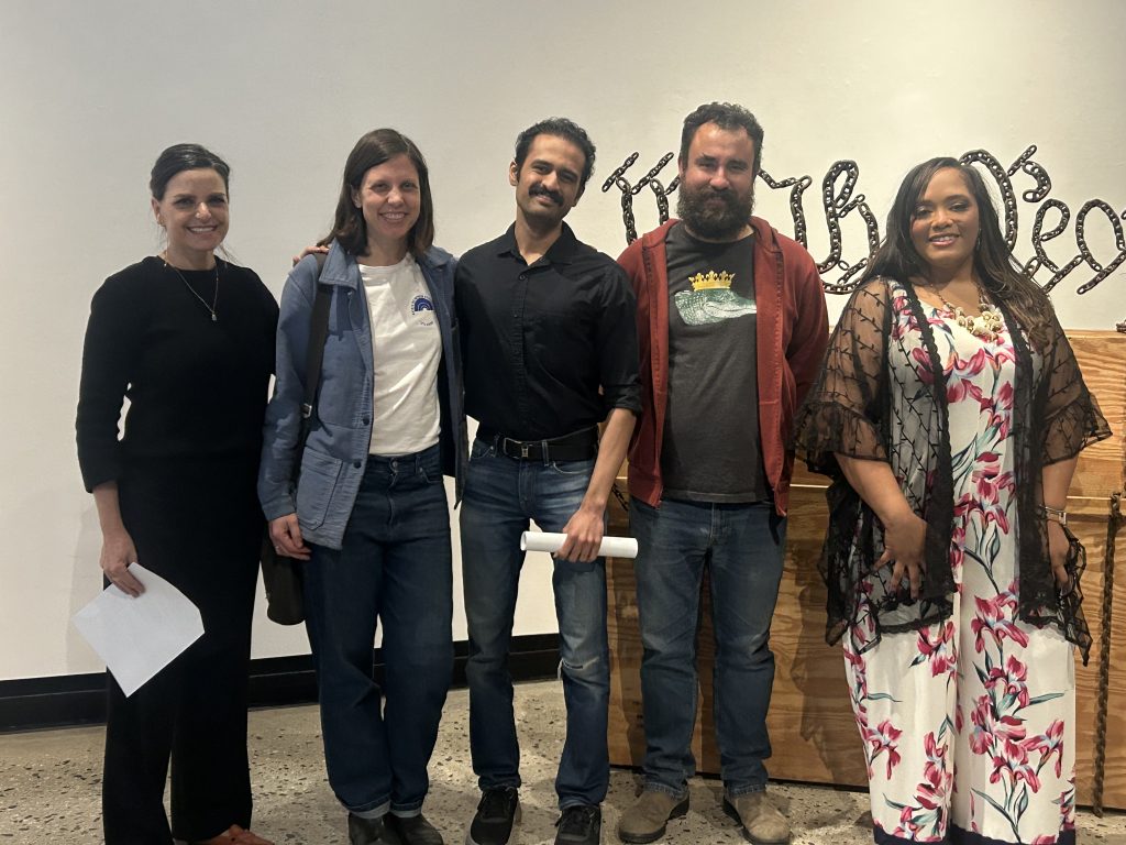 5 people pose in an art gallery.