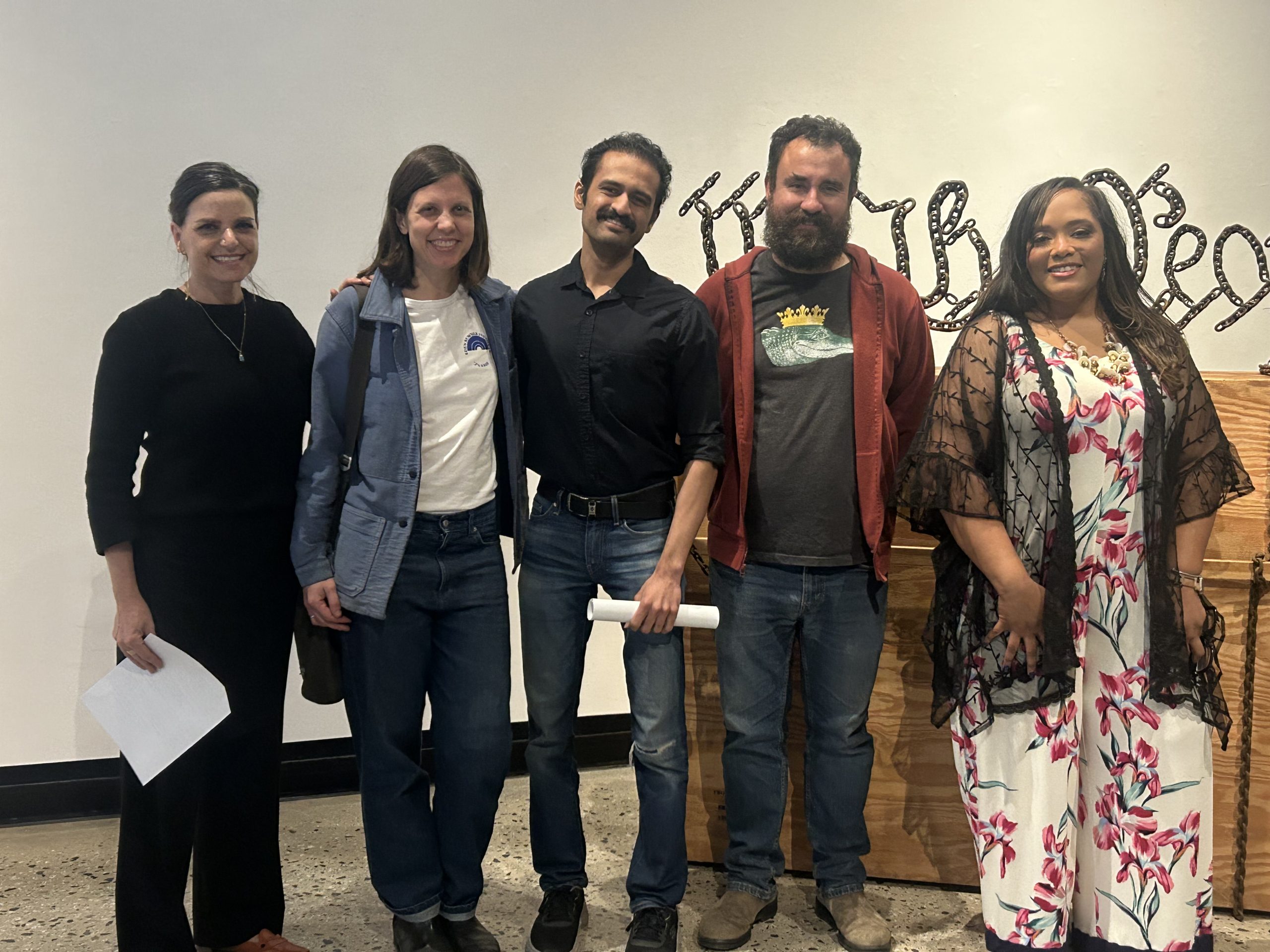 5 people pose in an art gallery.