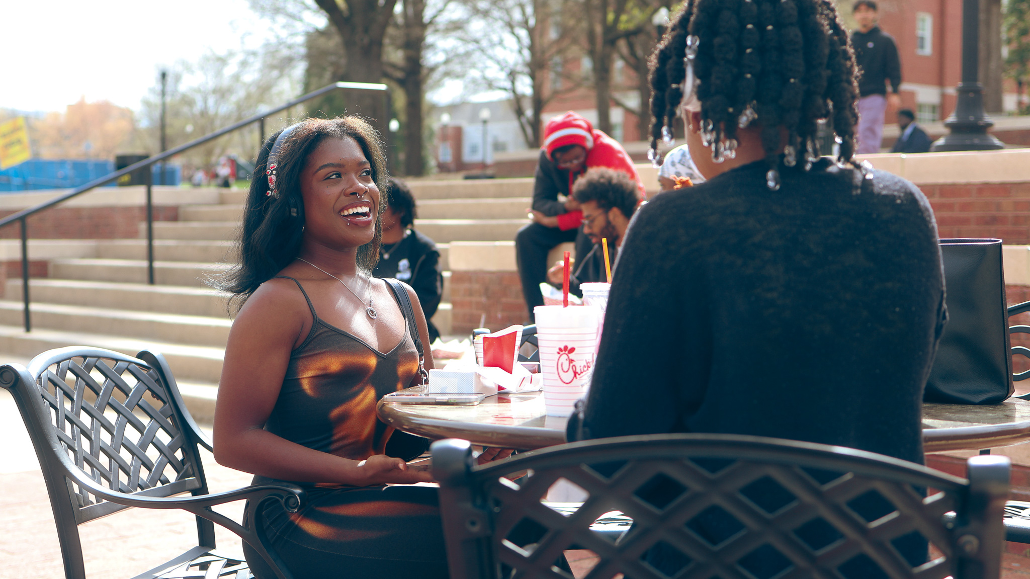 Students catching up over a meal on a sunny afternoon at the fountain.