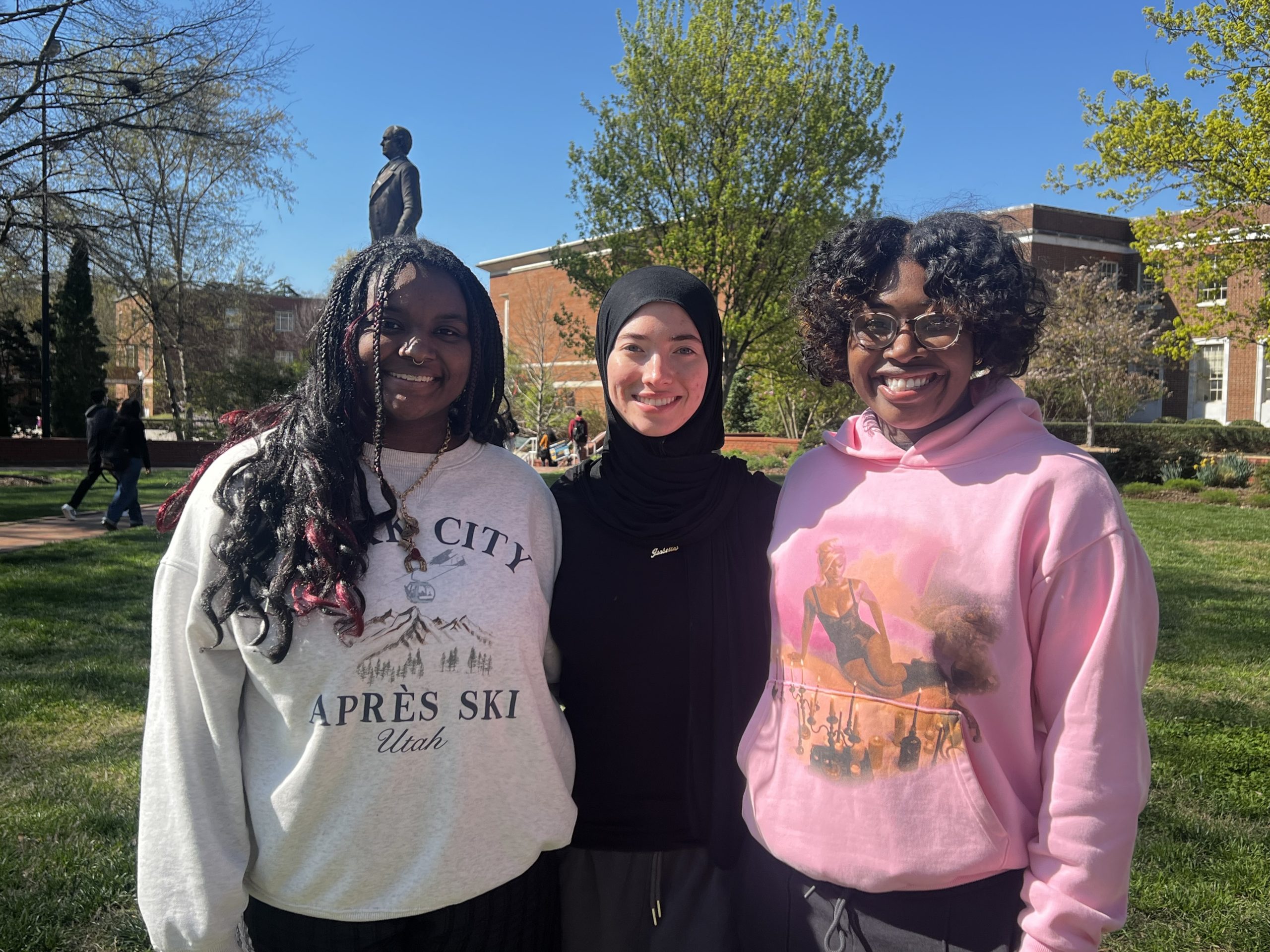 Three students pose on UNCG's campus.