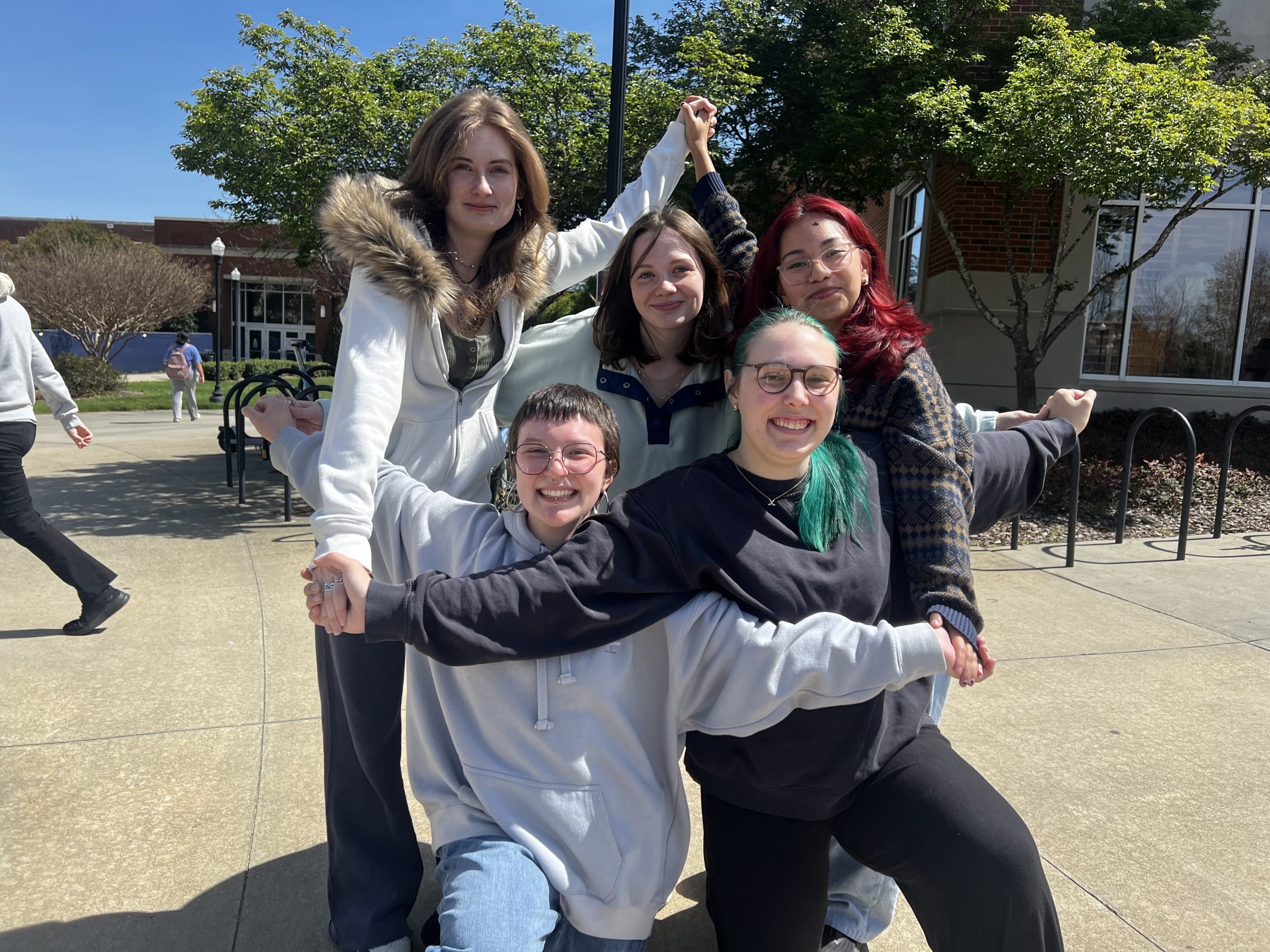 A group of students trying out a groo photo pose.