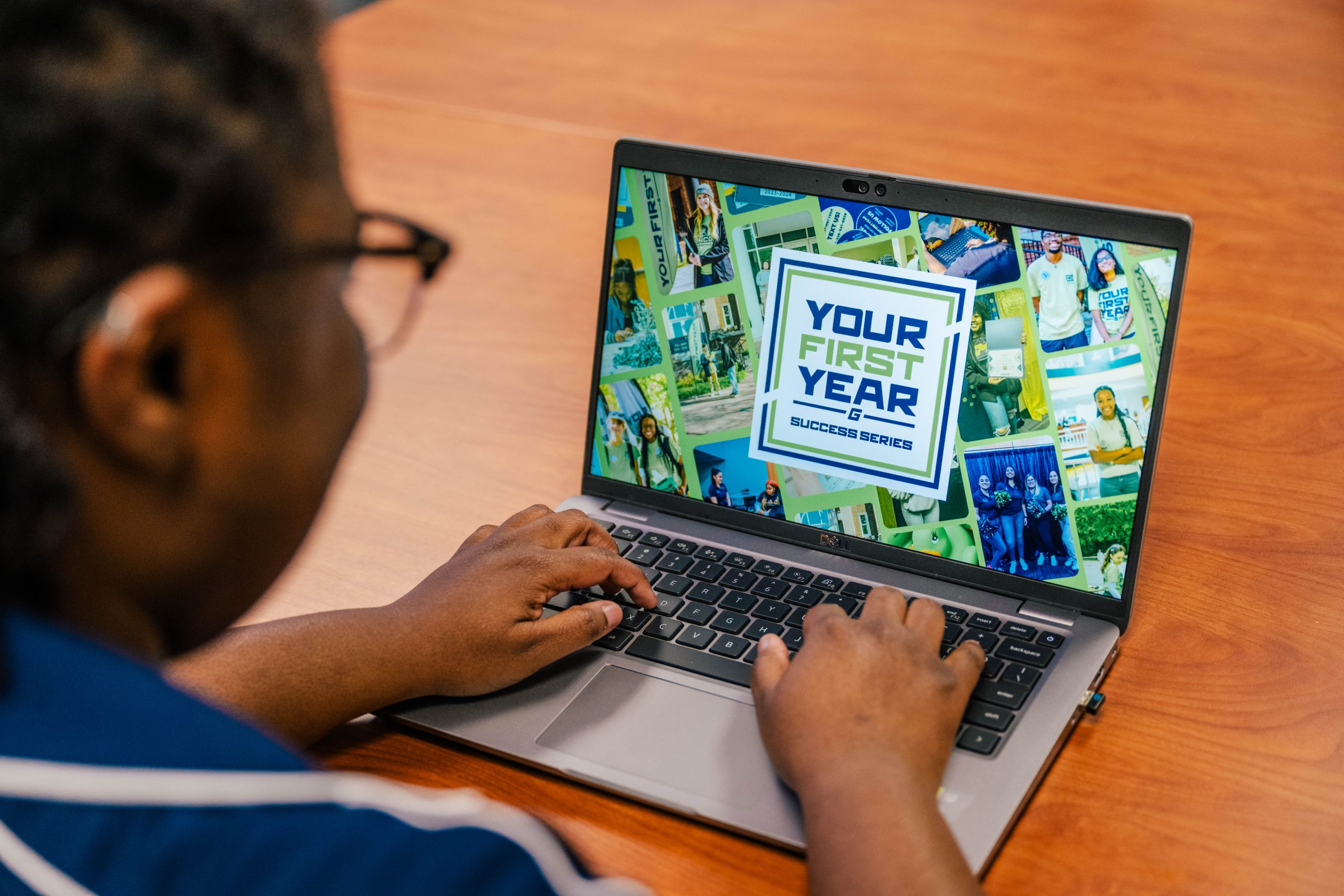 Person using a laptop displaying a colorful screen with the text 'Your First Year Success Series' surrounded by various images.