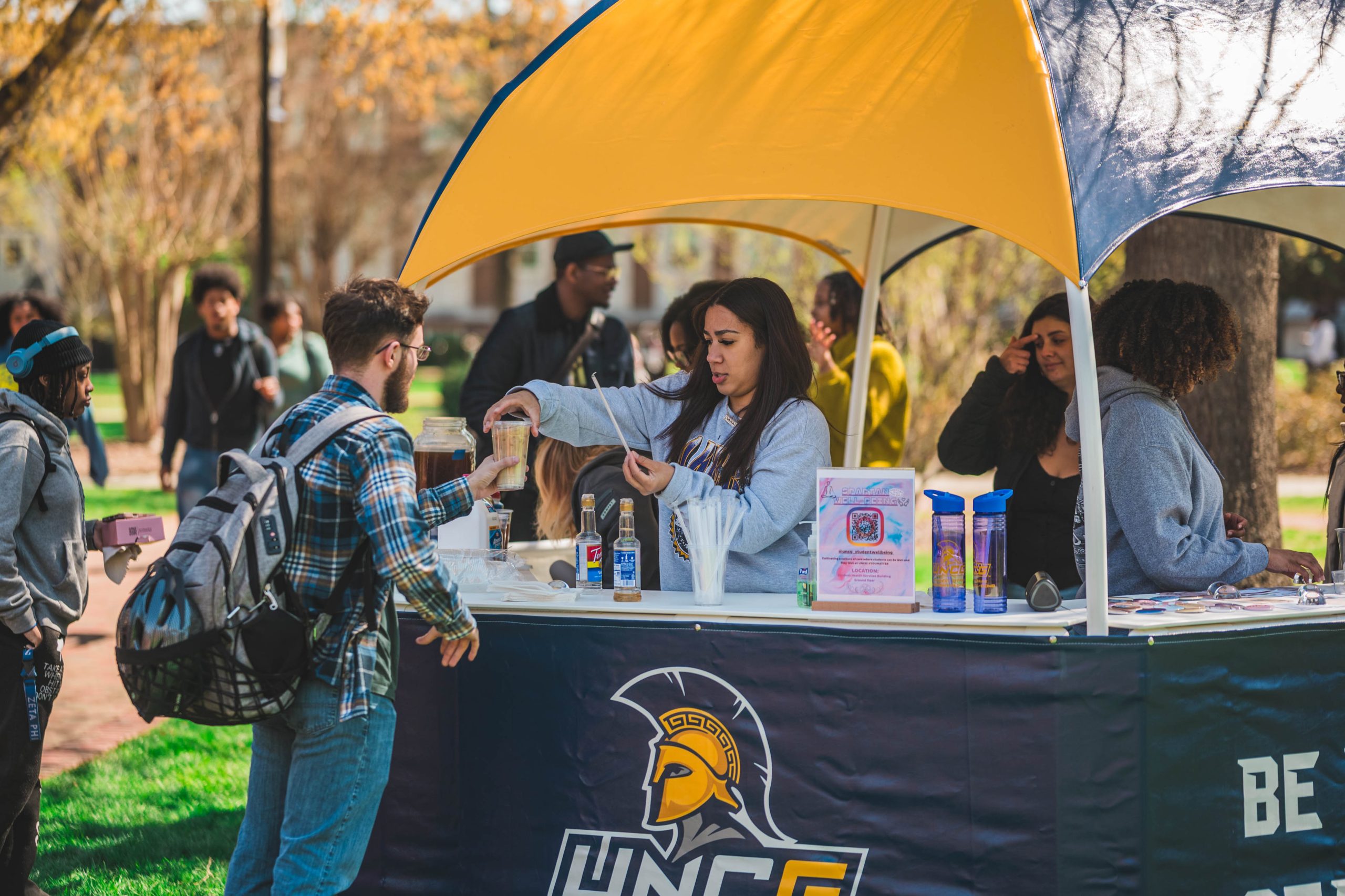 On the Jackson Library lawn, the organizers of Brewed for Thought talk to students about staying on track with their studies.
