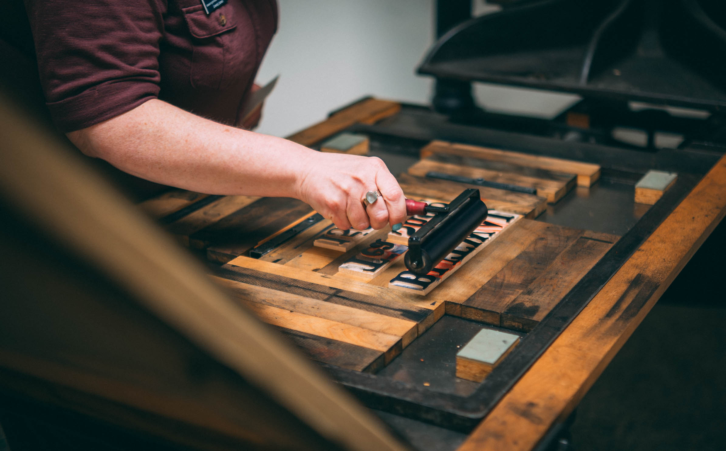 UNCG students learn about how to use a printmaking press from the 19th century at Special Collections and University Archives in Jackson Library.