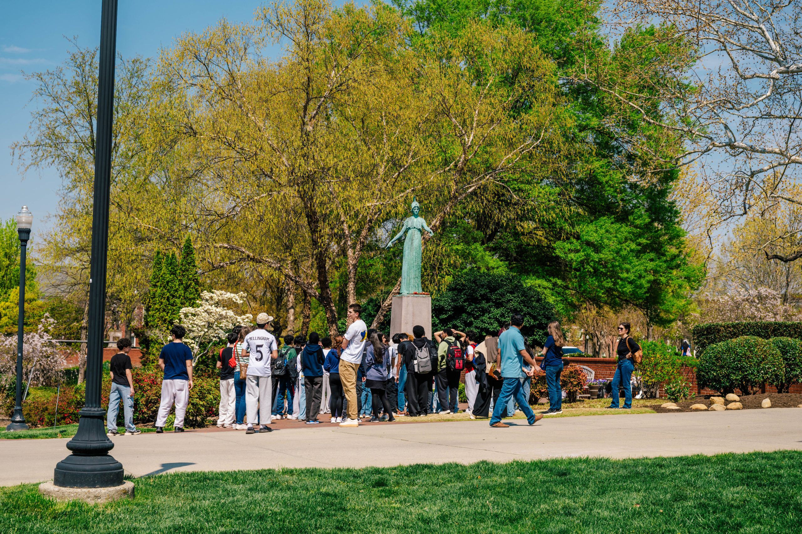 A group of prospective students gather at the Minerva statue on a tour of UNCG's campus.