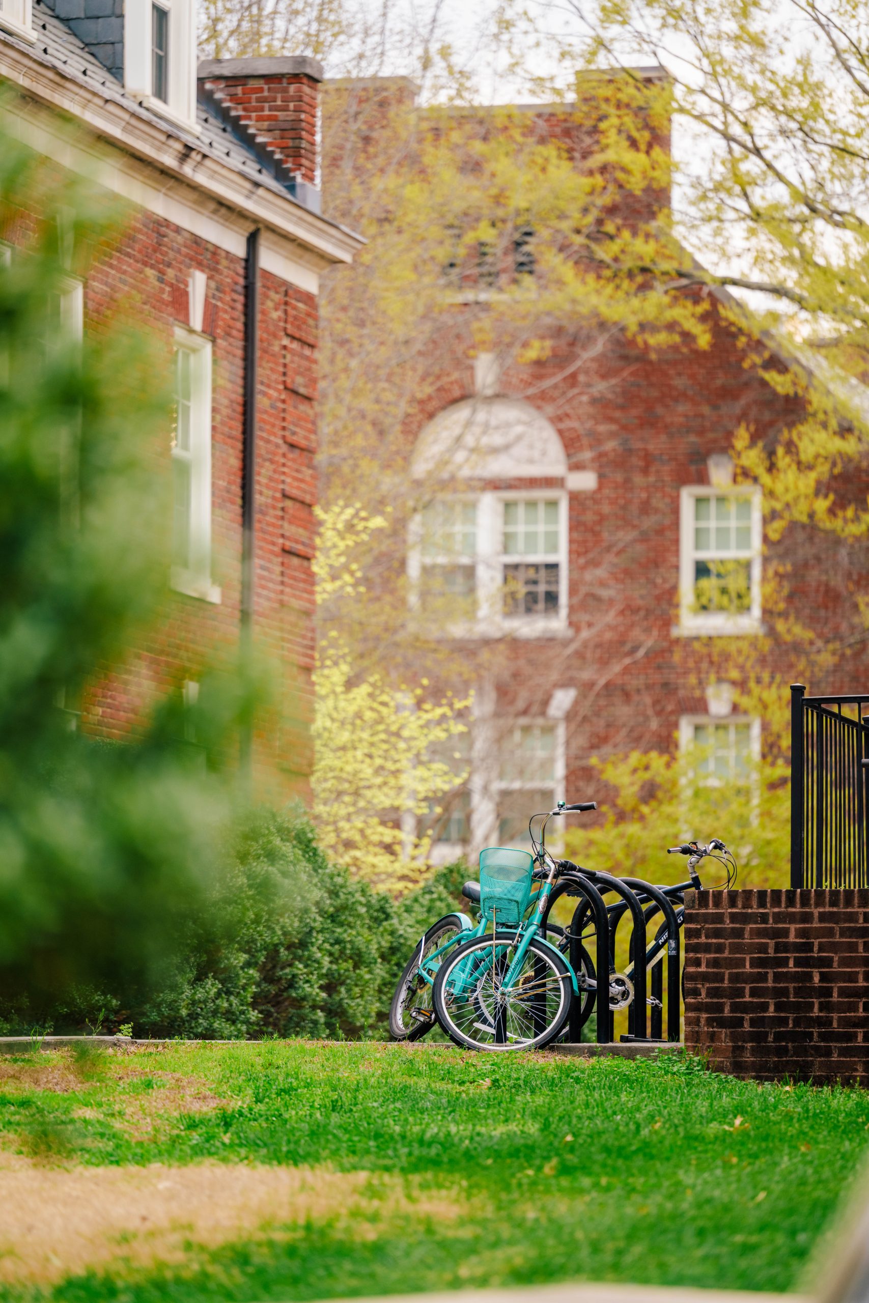 A student's bicycle leans on a bike rail on UNCG campus.