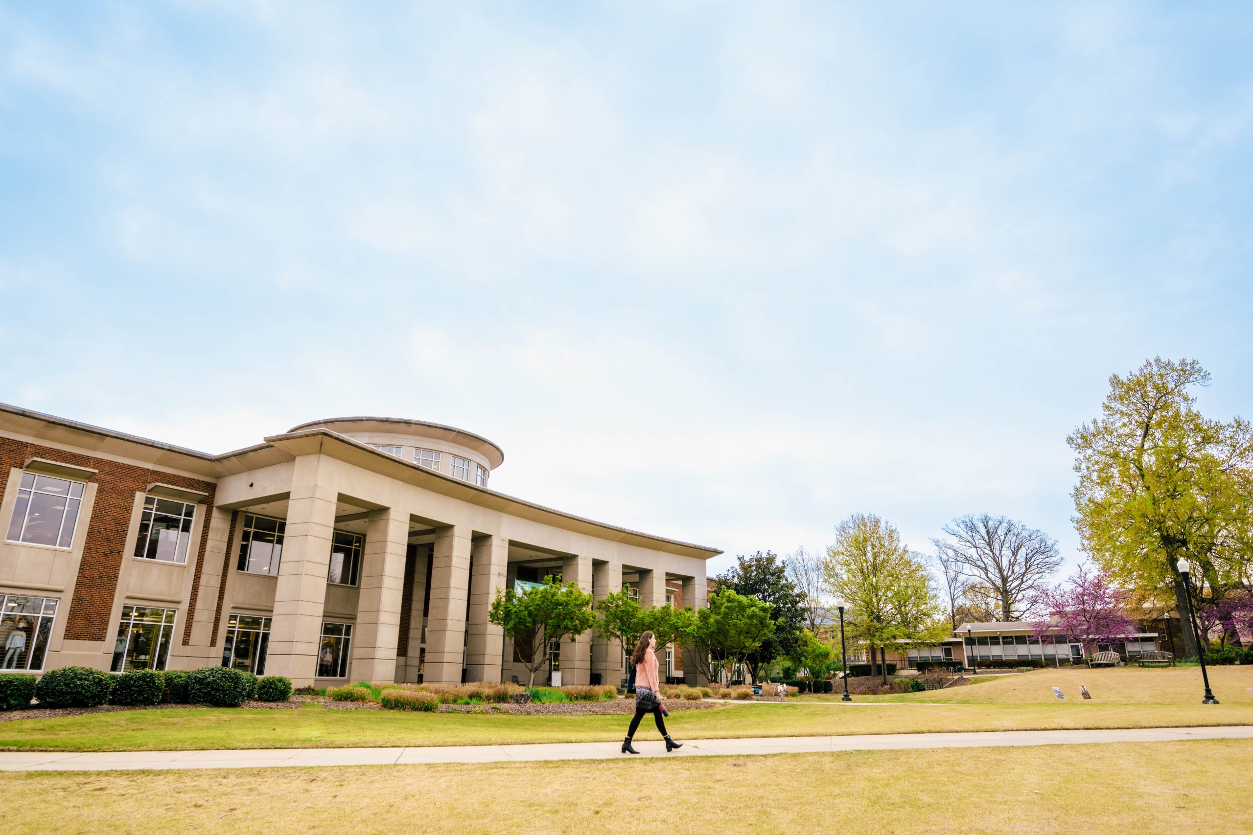 A student walks across Kaplan Commons in front of the Elliot University center on a beautiful morning.