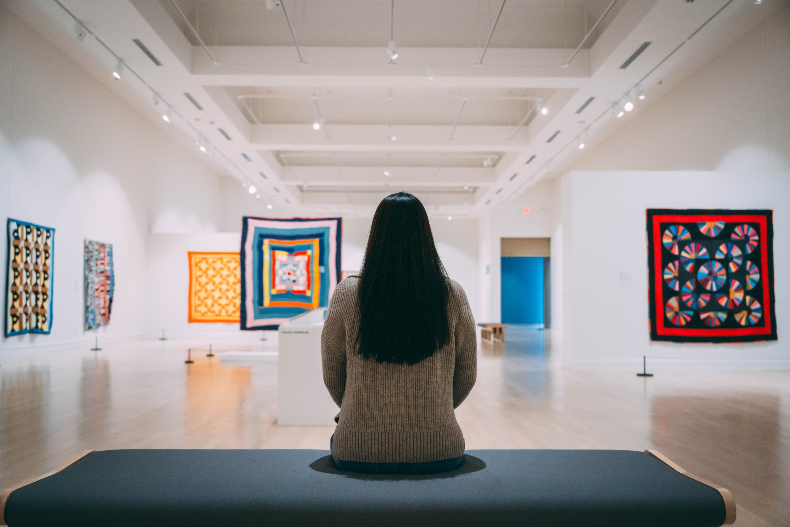 A student sits at the Weatherspoon taking in the new quilting exhibit.