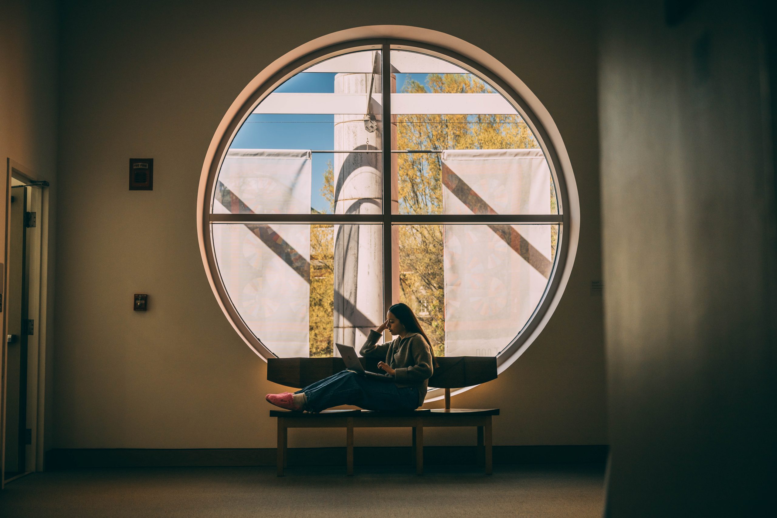 A grad student sits alone looking over notes, prepping for a rehearsal at the Weatherspoon Art Museum.